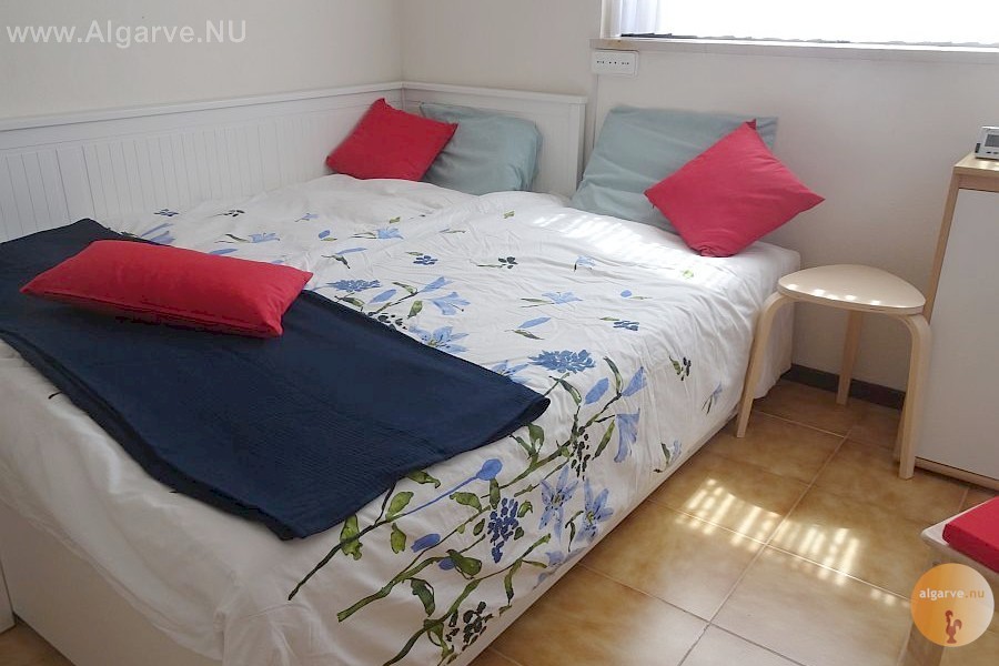 Slaapkamer met 1+1 bed en een gedeelde badkamer. Grote ventilator.